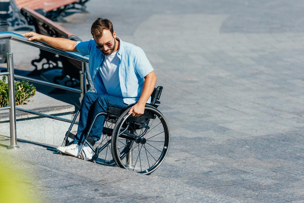 Minusválido en silla de ruedas con problemas para subir bordillo